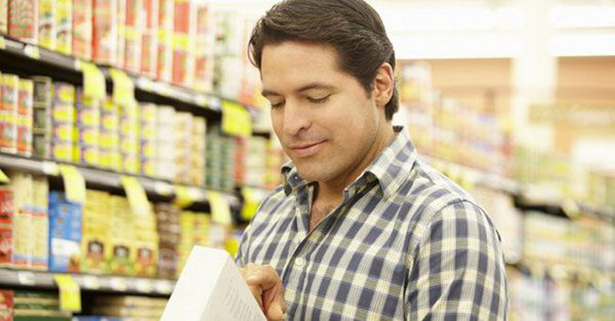 Man reading nutrition label on food product