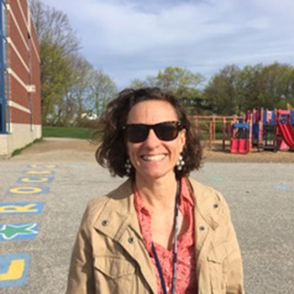 Rachael Flaxman in front of a playground, celebrating Teacher Appreciation Week