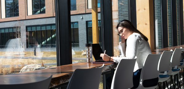 A woman engaged with her laptop while sitting at a table