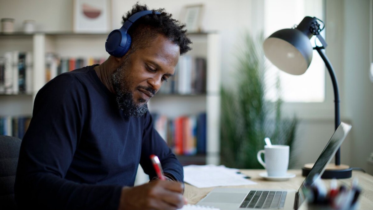 Man with bluetooth headphones working at home office