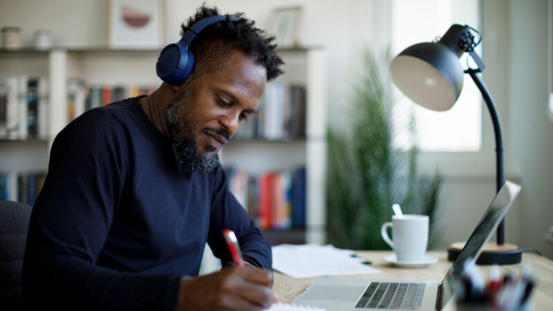 Man with bluetooth headphones working at home office