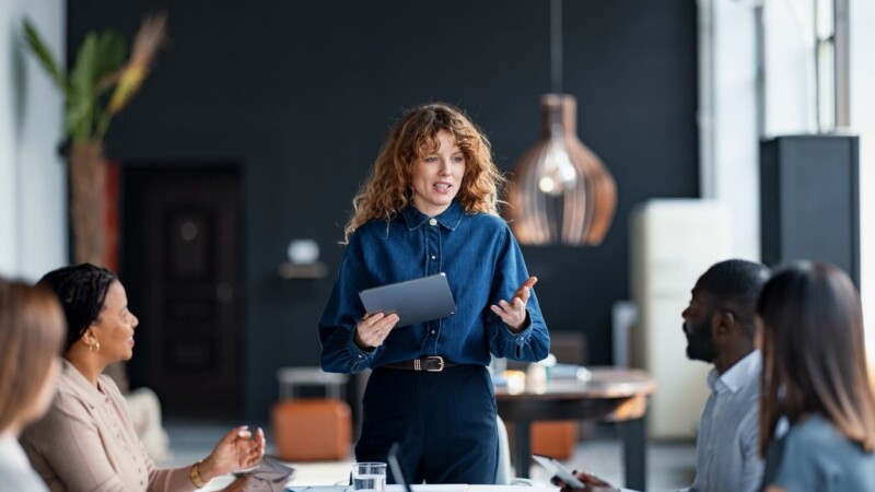 Business Professional Leading Team Presentation in Modern Office Setting