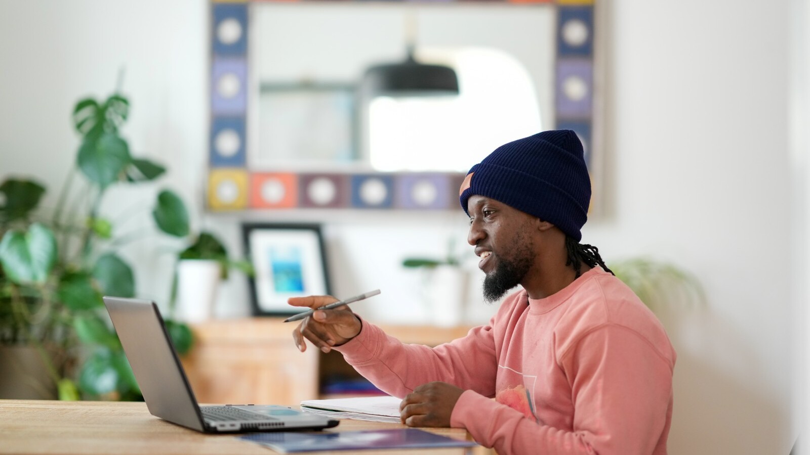 Student sitting at a table pointing to a laptop