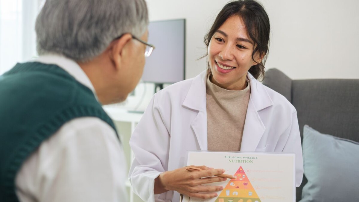 Doctor Explaining Healthy Eating and Food Pyramid to Senior Patient During Nutrition Counseling
