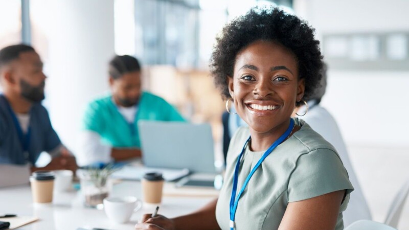 Black woman, portrait or happy doctor in meeting planning a surgery strategy or speaking of medical results in hospital. Teamwork, smile or African healthcare worker consulting, talking or working