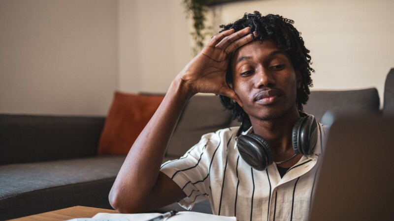 Stressed young man working from home feeling tired
