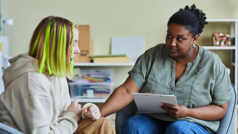 Psychologist working with upset girl at office