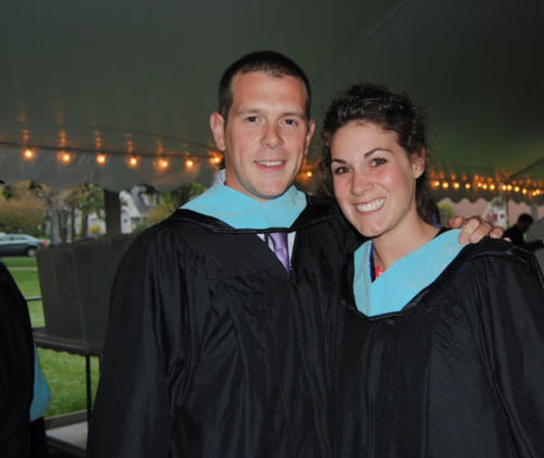 Two Master of Science in Education graduates in their light blue hoods